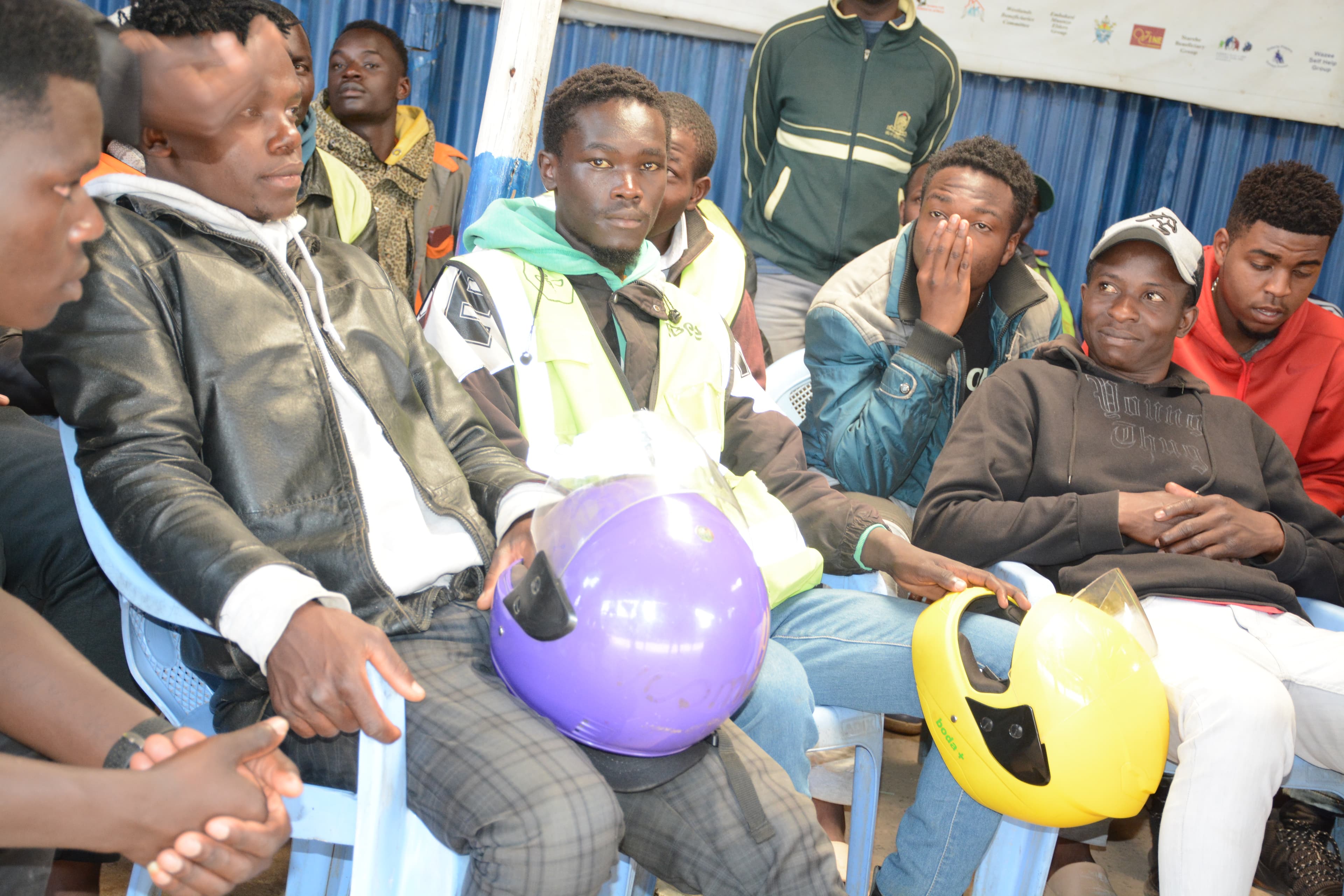 Participants hold helmets received during an ARUSi bodaa safety activity in Riruta.